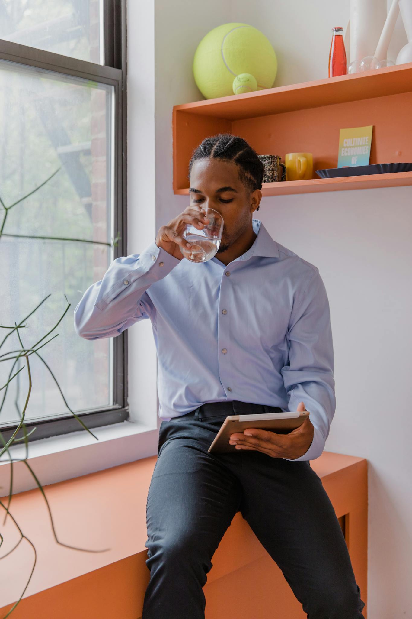 businessman drinking water while using tablet in